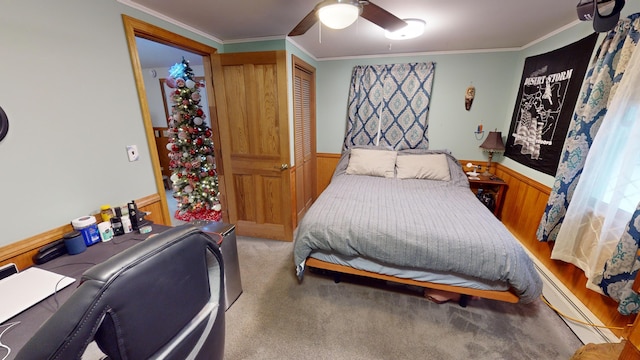 carpeted bedroom featuring ceiling fan, crown molding, a baseboard radiator, and wood walls