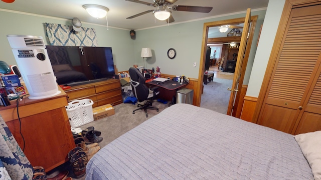 bedroom featuring carpet flooring, a closet, ceiling fan, and crown molding