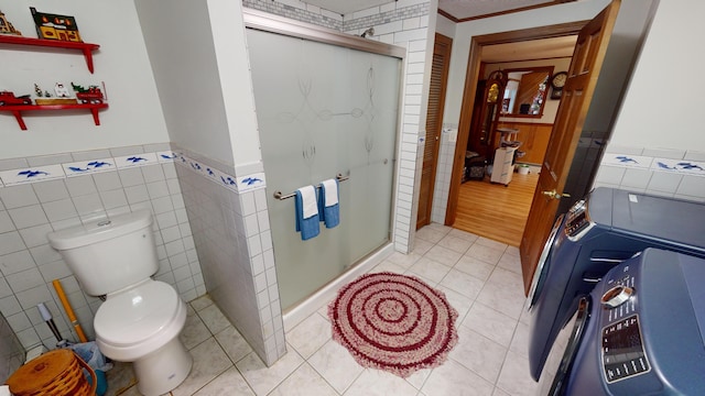 893 Horseback Rd, Levant, ME 04456 - bathroom featuring tile walls, tile patterned flooring, a shower stall, a wainscoted wall, and washer / clothes dryer
