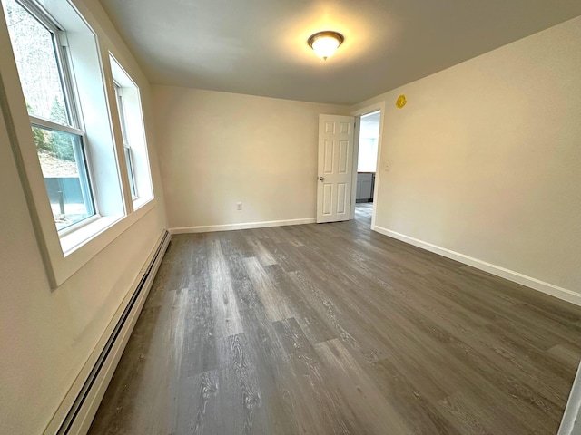 spare room featuring dark hardwood / wood-style flooring and baseboard heating