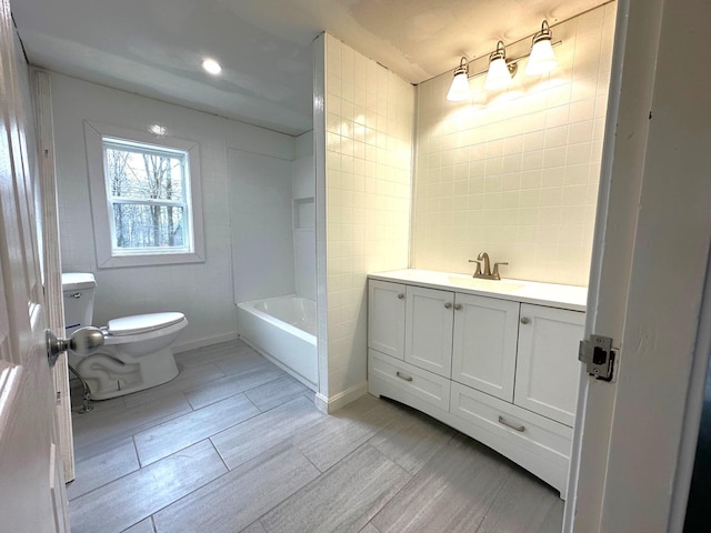 bathroom featuring vanity, toilet, and tile walls