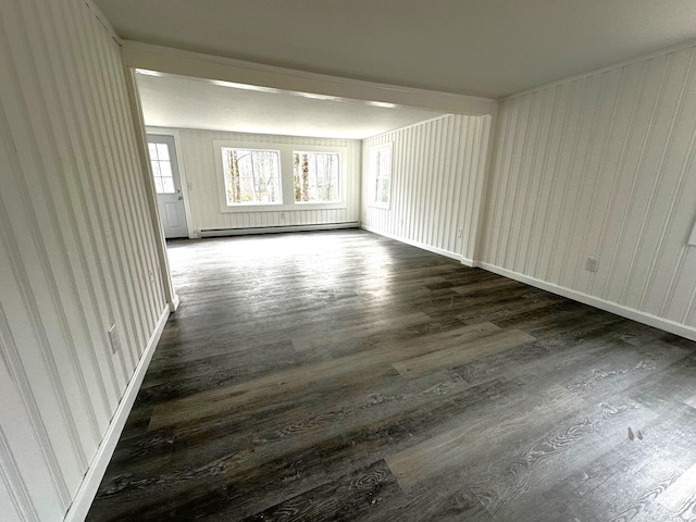 empty room with plenty of natural light, baseboard heating, and dark wood-type flooring