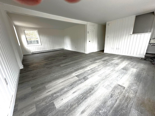 unfurnished room featuring baseboard heating and wood-type flooring