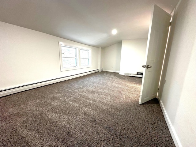 spare room featuring a baseboard radiator, lofted ceiling, and dark colored carpet