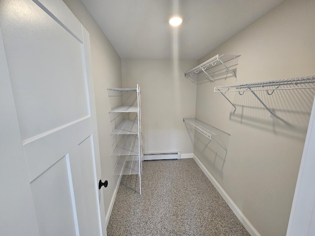 spacious closet featuring carpet floors and a baseboard heating unit