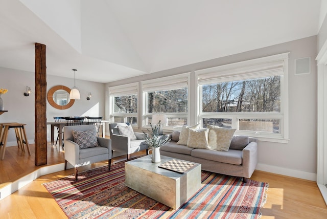 living room featuring lofted ceiling and light hardwood / wood-style flooring