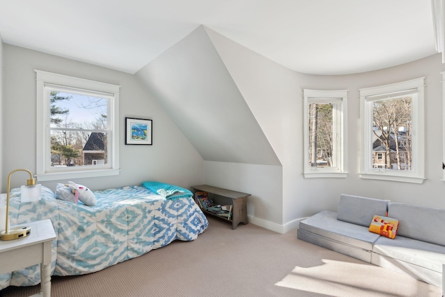 bedroom featuring carpet floors, vaulted ceiling, and multiple windows