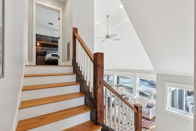 stairway featuring vaulted ceiling and ceiling fan