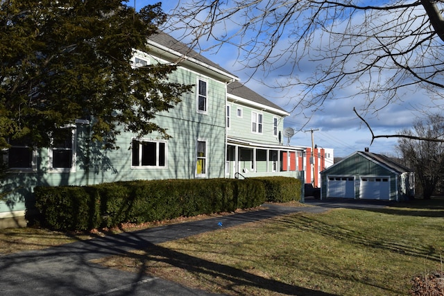 view of home's exterior featuring a yard, a garage, and an outdoor structure