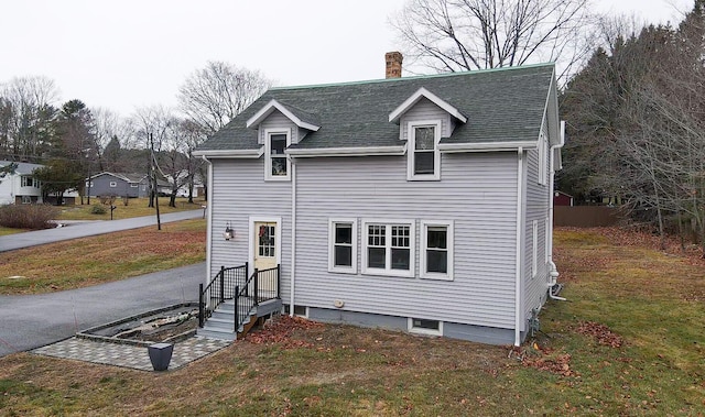 back of property featuring a lawn