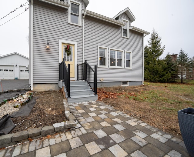 back of property featuring a garage and an outdoor structure