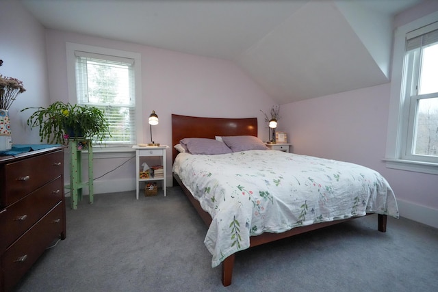 bedroom featuring vaulted ceiling, dark carpet, and multiple windows