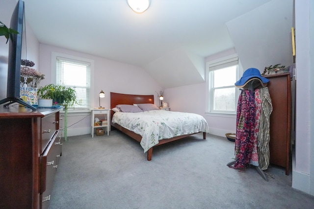 carpeted bedroom with lofted ceiling and multiple windows