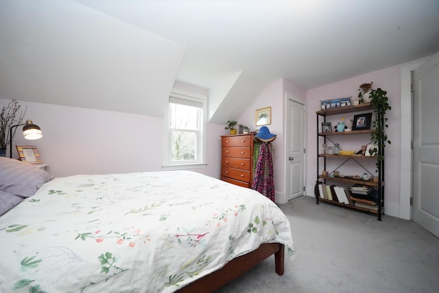 bedroom featuring lofted ceiling, a closet, and light carpet