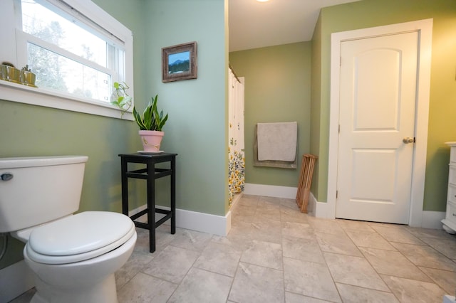 bathroom featuring toilet and curtained shower