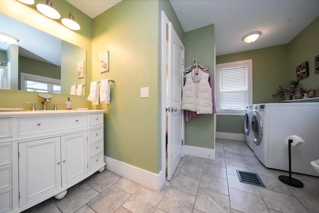 laundry room featuring washer and dryer, sink, and light tile patterned floors