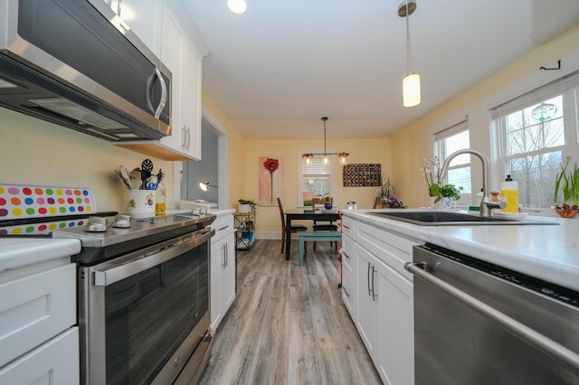 kitchen with sink, stainless steel appliances, and white cabinetry