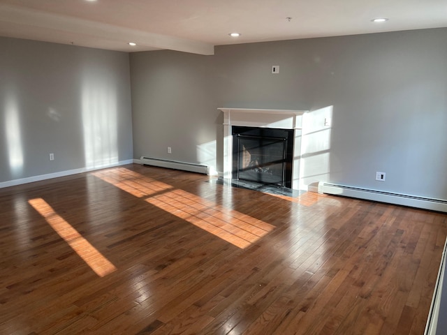 unfurnished living room with hardwood / wood-style floors and a baseboard radiator