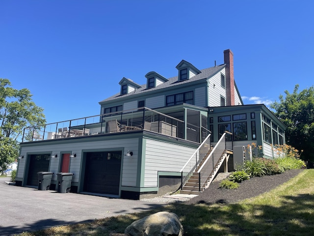 102 Main St, Belgrade, ME 04917 - rear view of property with a balcony, a garage, and a sunroom