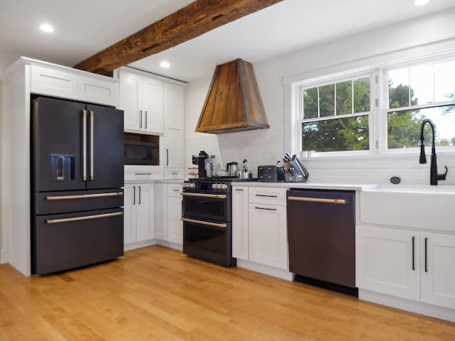 102 Main St, Belgrade, ME 04917 - kitchen with white cabinets, appliances with stainless steel finishes, premium range hood, and beam ceiling