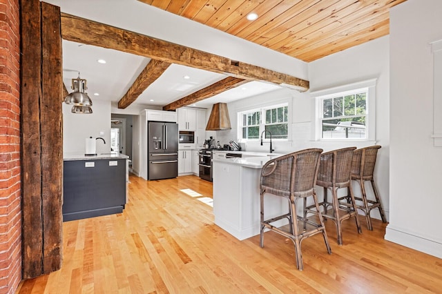 102 Main St, Belgrade, ME 04917 - kitchen with stainless steel refrigerator with ice dispenser, white cabinetry, beam ceiling, a kitchen bar, and kitchen peninsula