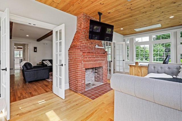 102 Main St, Belgrade, ME 04917 - bedroom featuring a fireplace, french doors, hardwood / wood-style flooring, and wooden ceiling