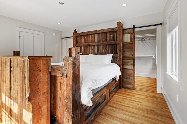 102 Main St, Belgrade, ME 04917 - bedroom featuring a barn door, light hardwood / wood-style flooring, and a closet