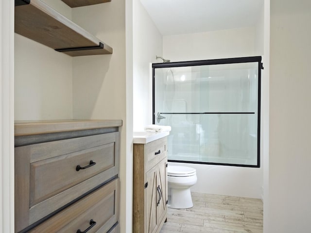 102 Main St, Belgrade, ME 04917 - full bathroom with hardwood / wood-style flooring, vanity, toilet, and shower / bath combination with glass door