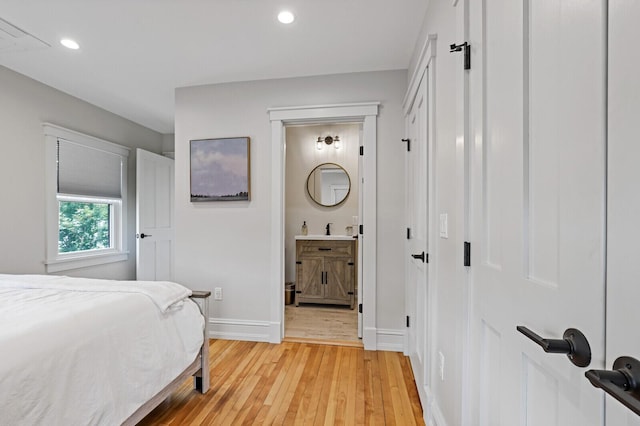 102 Main St, Belgrade, ME 04917 - bedroom with ensuite bath, sink, and light wood-type flooring