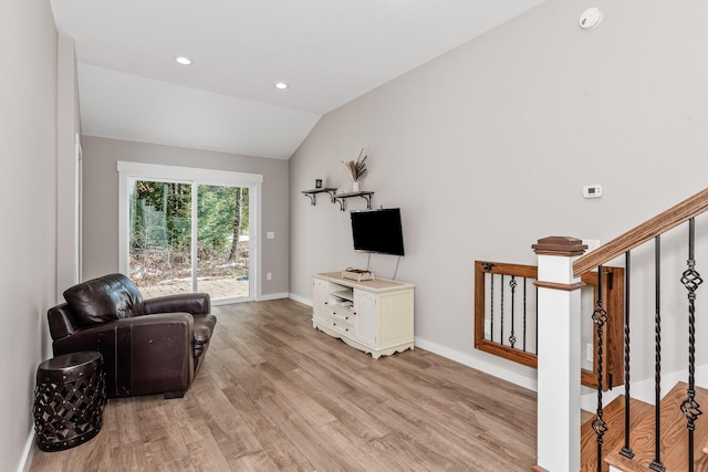 living room featuring vaulted ceiling and light hardwood / wood-style floors