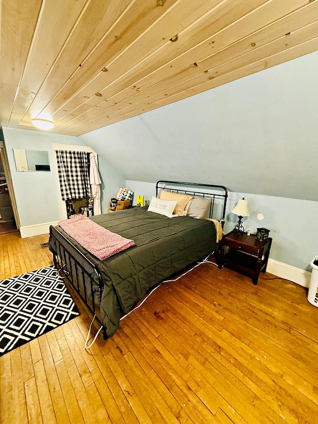 bedroom with hardwood / wood-style flooring, wooden ceiling, and vaulted ceiling