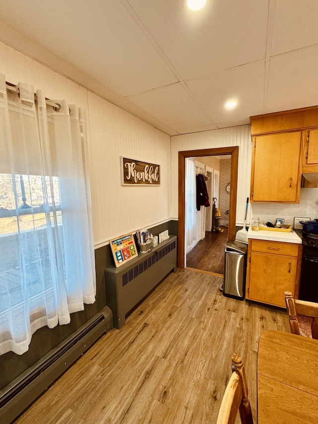 kitchen featuring black stove, light hardwood / wood-style flooring, and a baseboard radiator