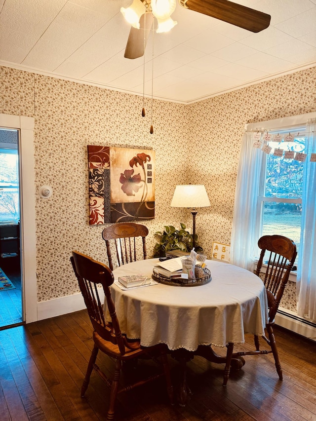 dining space with ceiling fan, dark wood-type flooring, and ornamental molding