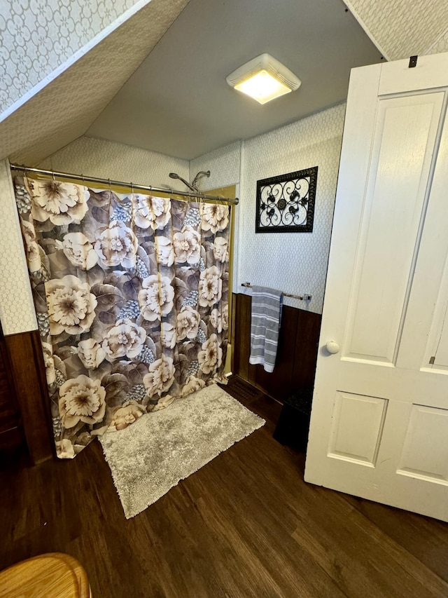 bathroom featuring wood-type flooring and vaulted ceiling