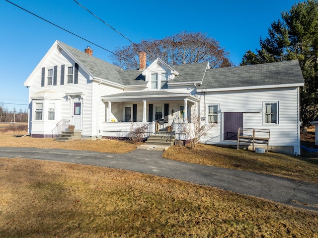 new england style home featuring a front yard and a porch