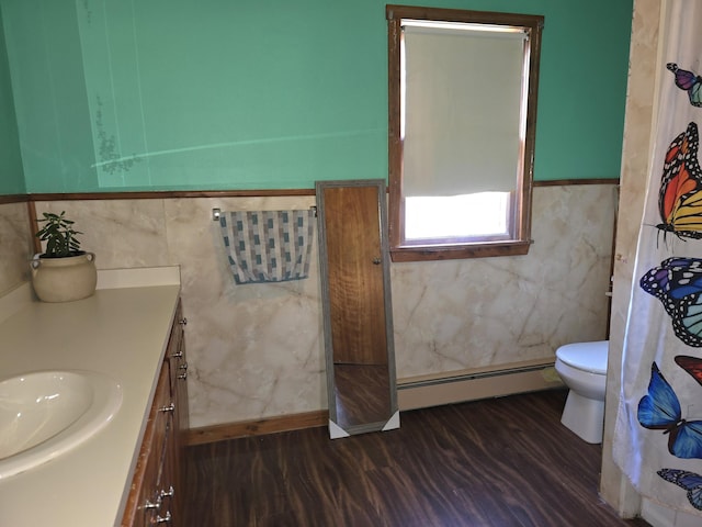 bathroom with toilet, hardwood / wood-style floors, vanity, and a baseboard heating unit