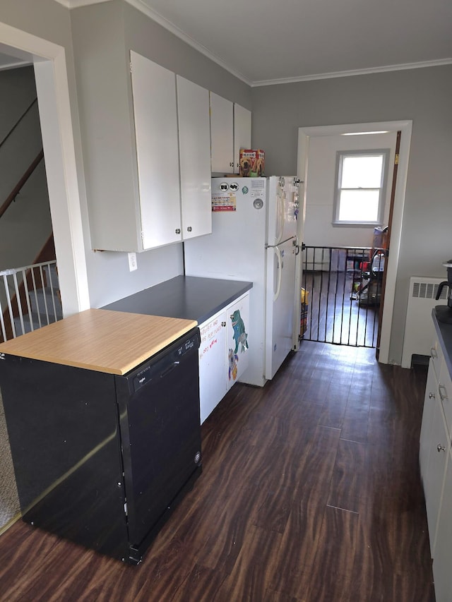 kitchen with white cabinets, refrigerator, dark wood-type flooring, and crown molding