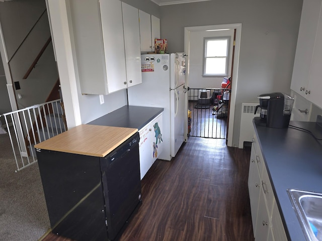 kitchen featuring radiator, sink, white fridge, dark hardwood / wood-style floors, and white cabinetry