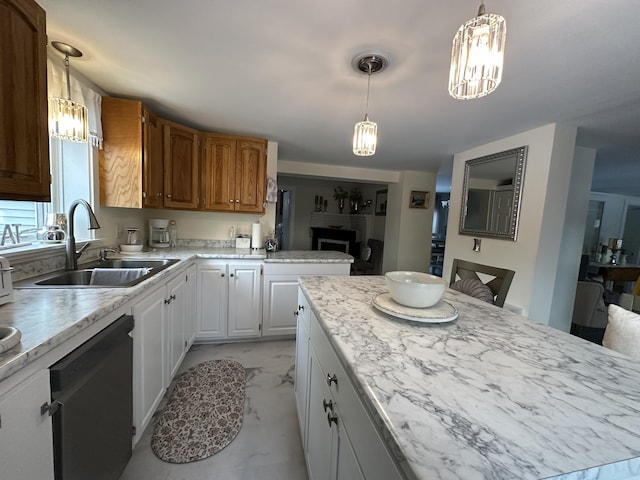 kitchen featuring hanging light fixtures, black dishwasher, sink, and white cabinetry