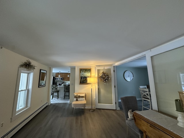 living room with baseboard heating and dark hardwood / wood-style flooring