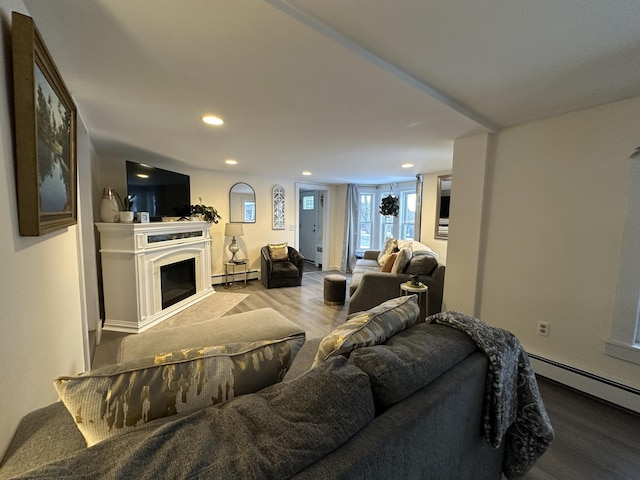 living room with a baseboard heating unit and light hardwood / wood-style flooring