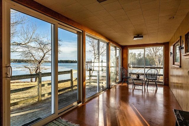 unfurnished sunroom with a healthy amount of sunlight and a water view