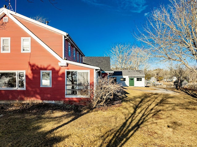 view of property exterior featuring a lawn and an outbuilding