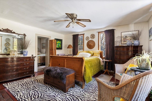 bedroom with multiple windows, ensuite bathroom, and ceiling fan