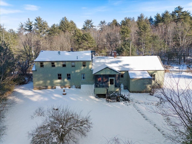 view of snow covered back of property