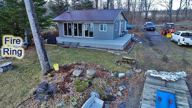 view of side of home with metal roof and a lawn