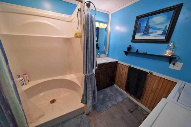 full bath with a washtub, walk in shower, wood finished floors, and vanity