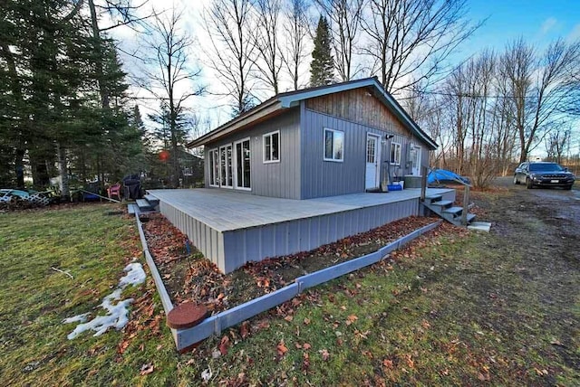 view of home's exterior with a deck and a yard