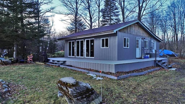 view of home's exterior with metal roof, a deck, and a lawn