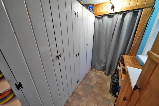 bathroom with wooden walls and stone finish floor